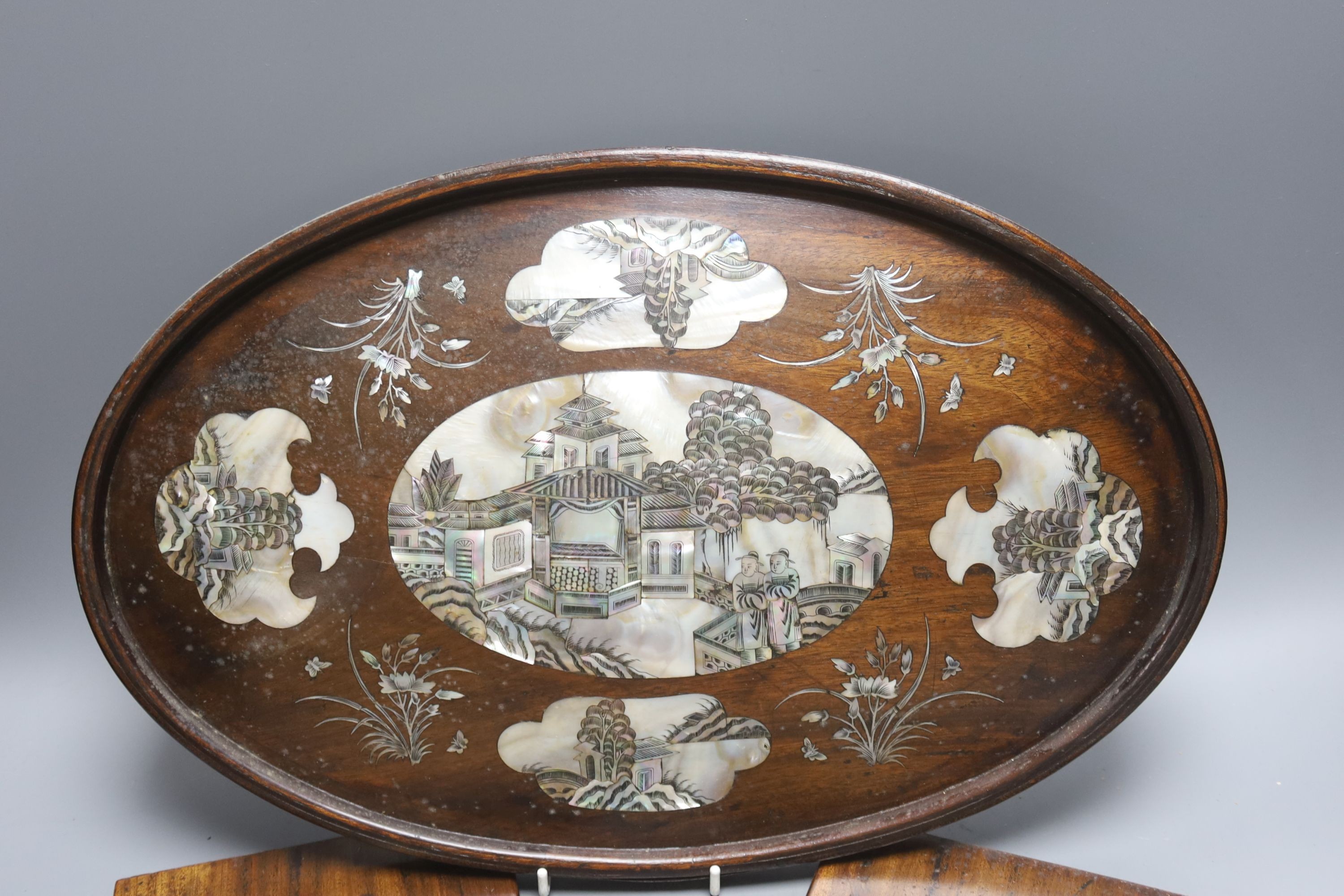 A Chinese hardwood and mother of pearl inlaid oval tray, 43cm and a similar pair of panels decorated with figures